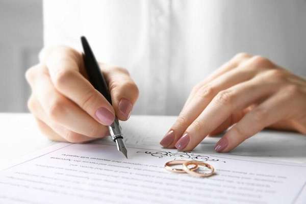 обручальные кольца и брачный контракт на столе