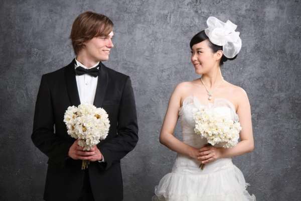 невеста корейской национальности и жених держат свадебные букеты