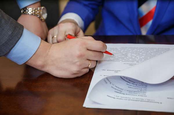 подпись документа ручкой, руки на столе