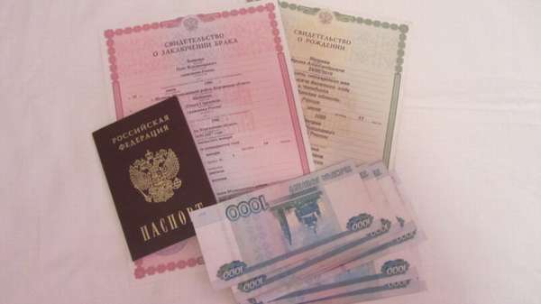 свидетельство о заключении брака, свидетельство о рождении, российский паспорт и деньги на столе
