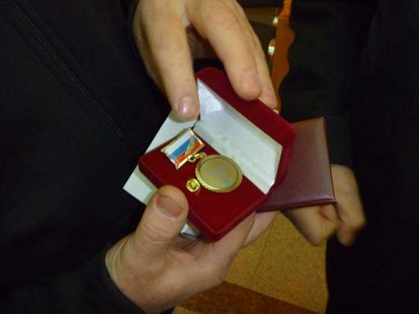 медаль ветерана труда РФ в красной замшевой шкатулке в руках