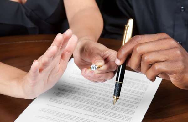 кольцо и ручка в руках, документ на столе