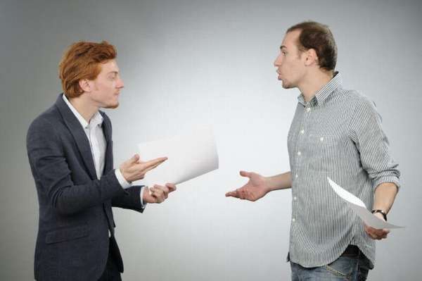 два мужчины разговаривают и держат в руках документы