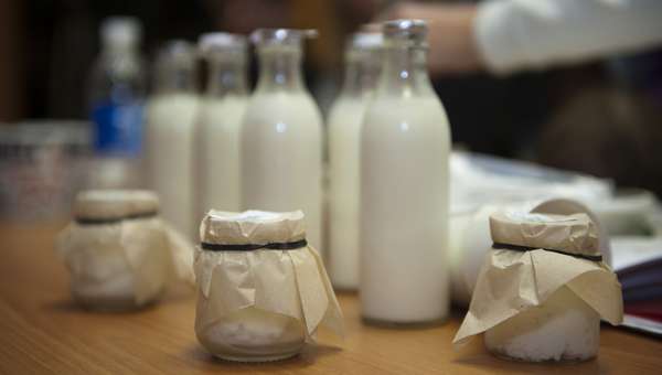 бутылки с молоком и баночки с творожной смесью на столе