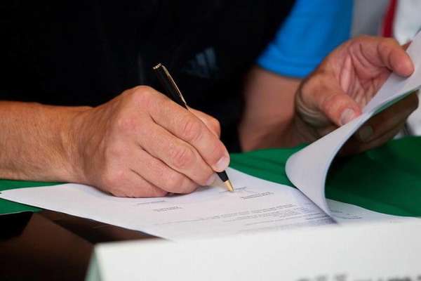 подписывание документа ручкой на столе